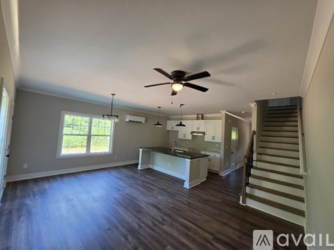 A spacious living room with a staircase leading to the upper floor.