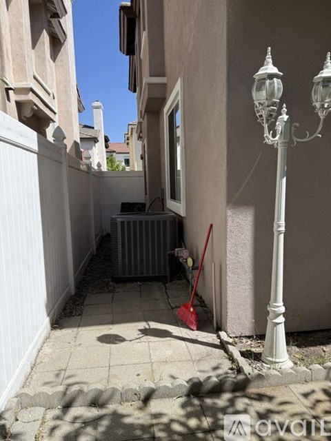A small alley with a lamp post and a broom.