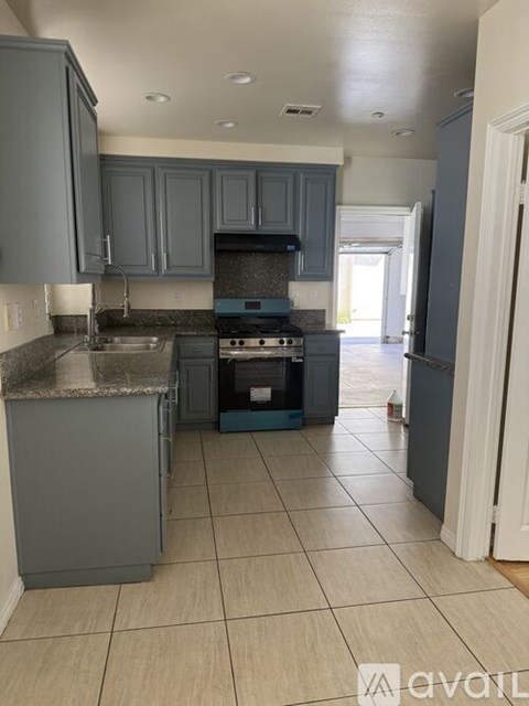 A kitchen with a stove top oven and a refrigerator.