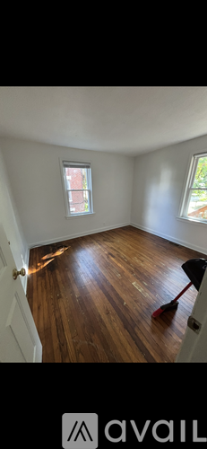 A room with wooden flooring and a window.