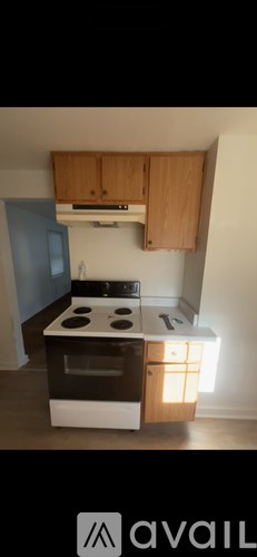 A kitchen with wooden cabinets and a white stove top oven.