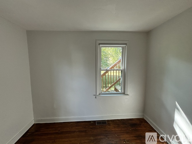 A room with a window and wooden floors.