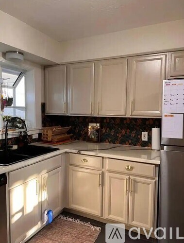 A kitchen with beige cabinets and a black countertop.