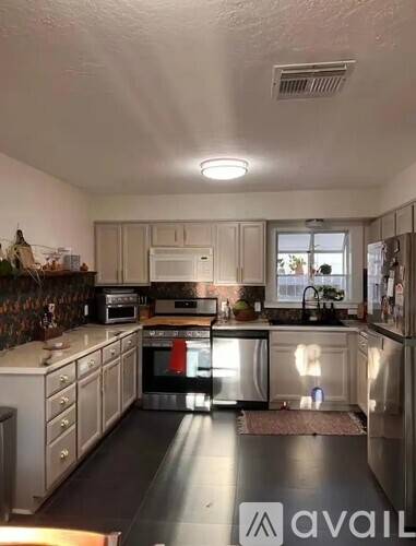 A kitchen with a black floor and white walls.