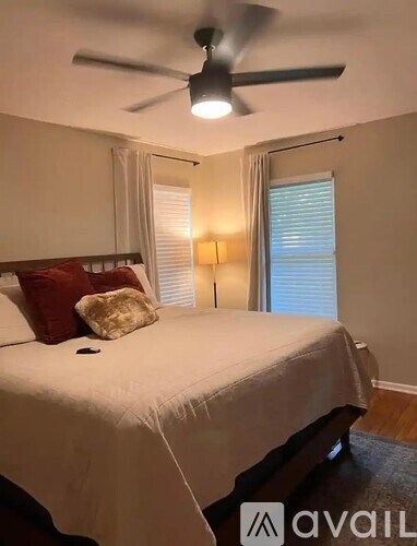 A bedroom with a bed, pillow, and a ceiling fan.