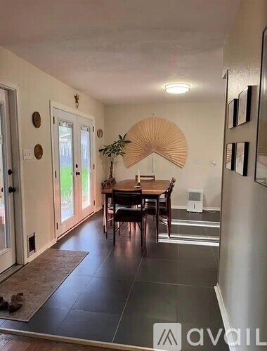 A dining room with a wooden table and chairs.