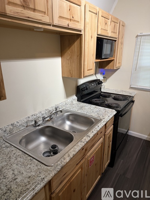 A kitchen with granite countertops and wooden cabinets.
