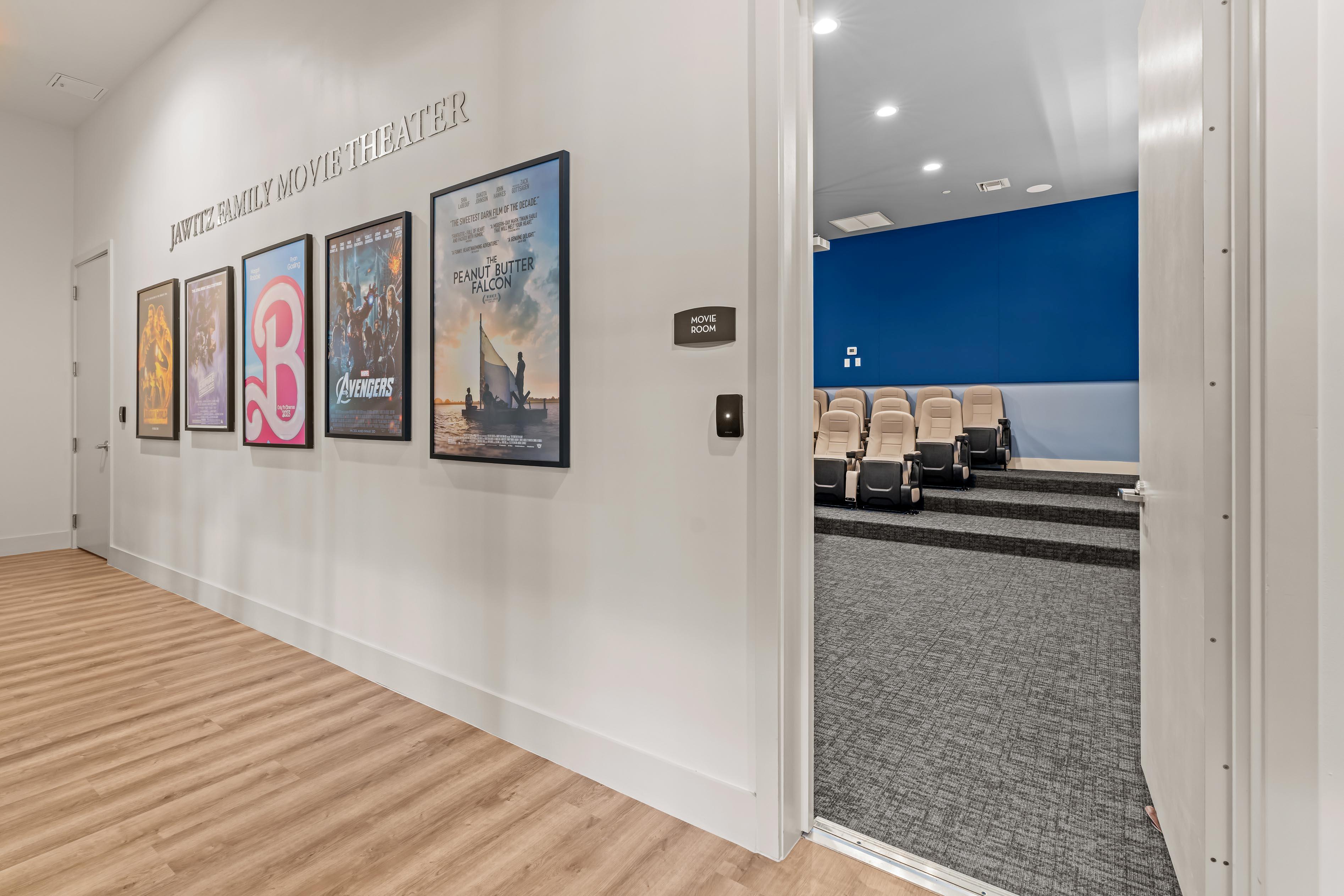 A hallway with posters on the wall and chairs in the distance.