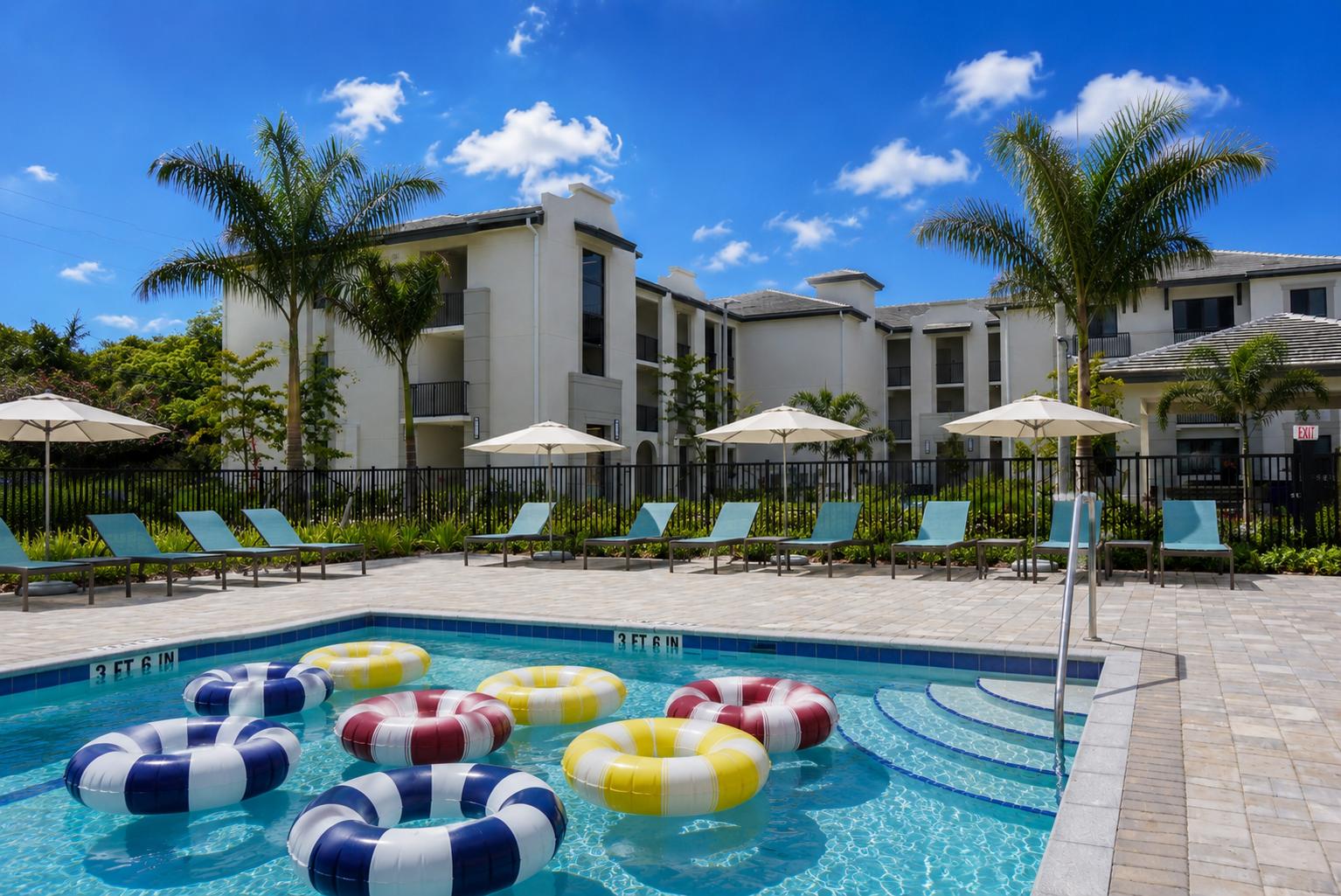 A pool with blue water and colorful floaties.