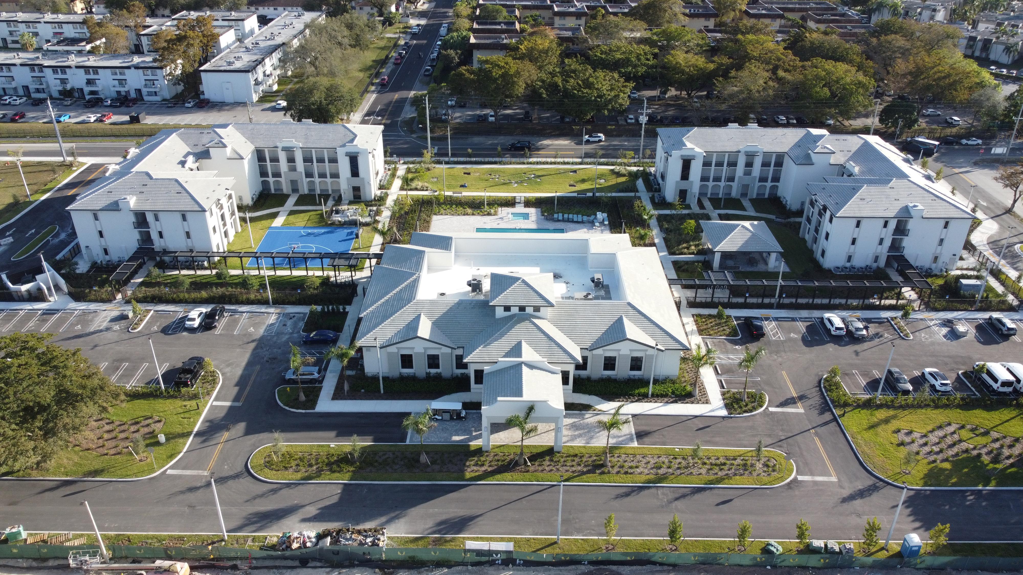 A large white building with a pool in the middle of a parking lot.