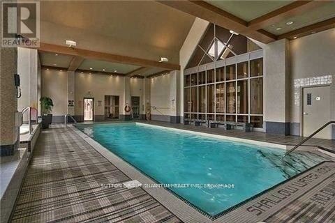 A large indoor swimming pool with a tiled floor and walls.