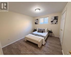 A bedroom with a bed, nightstands, and pictures on the wall.