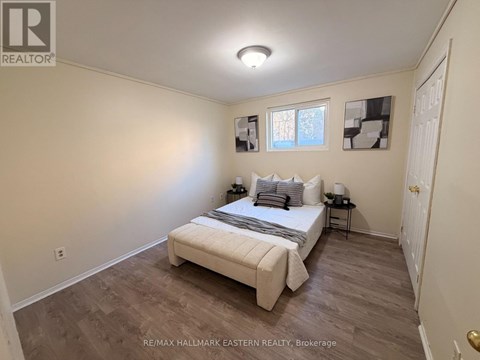 A bedroom with a bed, nightstands, and pictures on the wall.