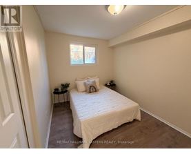 A bedroom with a bed, nightstands, and a window.
