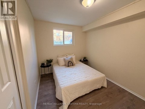 A bedroom with a bed, nightstands, and a window.