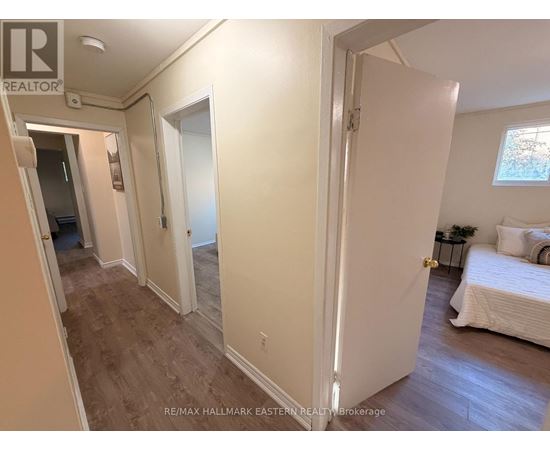 A bedroom with a bed, nightstand, and window.
