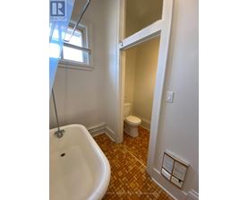 A bathroom with a white tub and toilet.