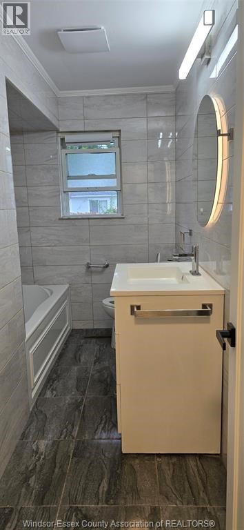 A bathroom with a sink, toilet, and tub.