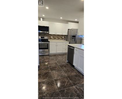 A kitchen with white cabinets and a black stove top oven.