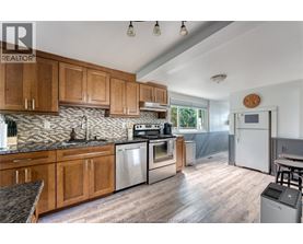 A kitchen with wooden cabinets and a stainless steel refrigerator.