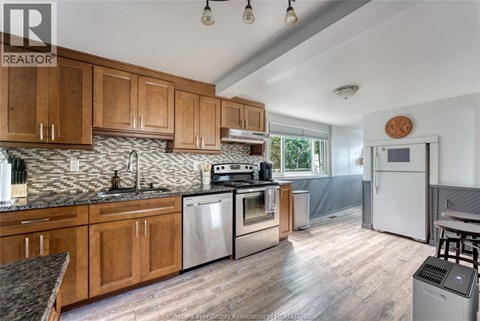 A kitchen with wooden cabinets and a stainless steel refrigerator.