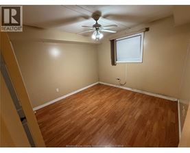A room with wooden flooring and a ceiling fan.