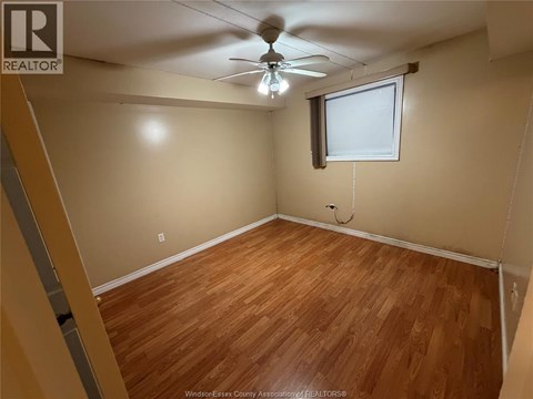 A room with wooden flooring and a ceiling fan.