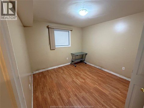 A room with wooden flooring and a small table.