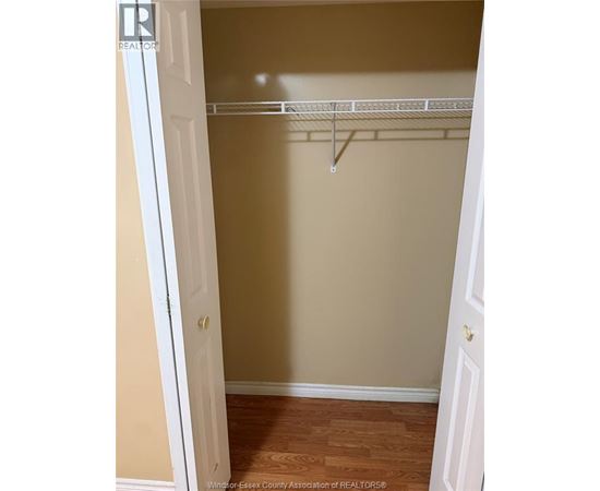 A white door is open to a room with a white shelf.