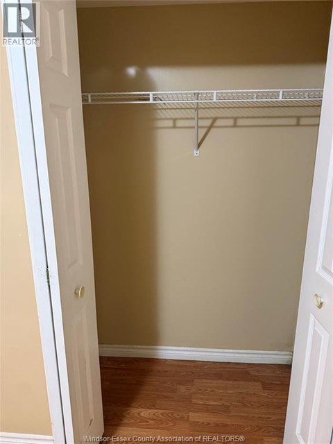 A white door is open to a room with a white shelf.