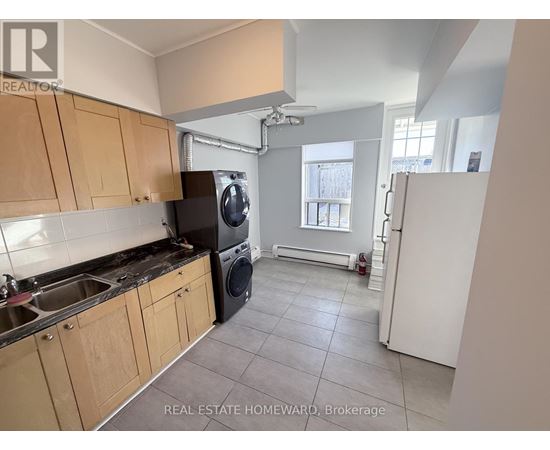 A kitchen with wooden cabinets and a black dishwasher.