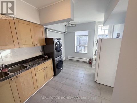 A kitchen with wooden cabinets and a black dishwasher.