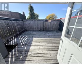 A wooden deck with a bench and a fence.