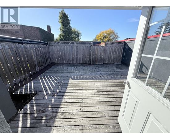 A wooden deck with a bench and a fence.