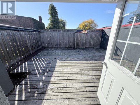 A wooden deck with a bench and a fence.