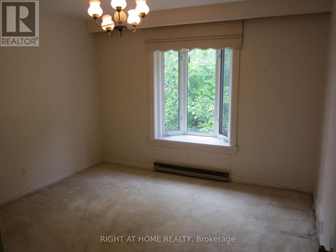 A room with a window and a chandelier.