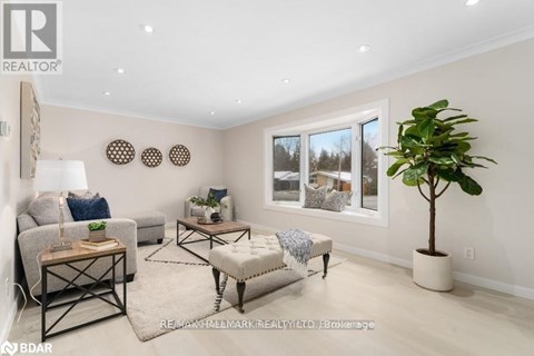 A well-lit living room with a grey sofa, a wooden coffee table, and a large window with a view of the outdoors.