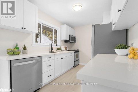 A modern kitchen with white cabinets and appliances.