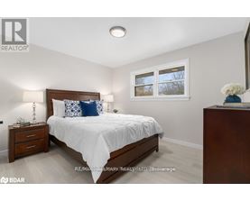 A bedroom with a bed, nightstand, and window.