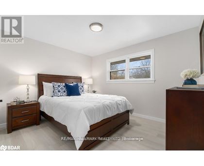 A bedroom with a bed, nightstand, and window.