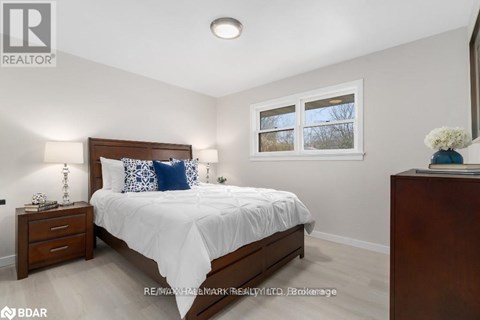 A bedroom with a bed, nightstand, and window.