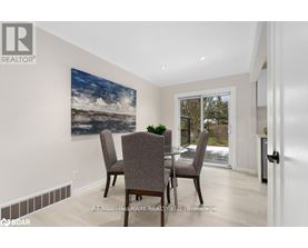 A dining room with a large painting on the wall and a glass table with chairs.