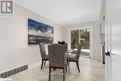 A dining room with a large painting on the wall and a glass table with chairs.