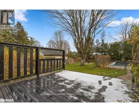A deck with a railing and a pool in the backyard.