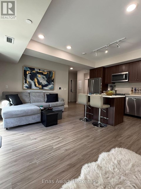 A modern living room with a grey couch and a painting on the wall.