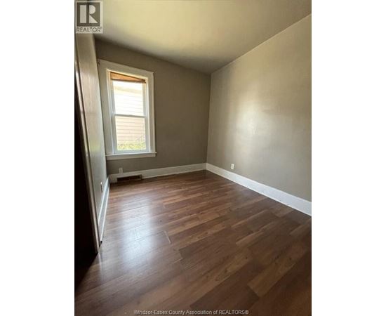 A room with wooden flooring and a window.