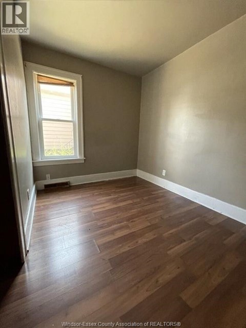 A room with wooden flooring and a window.