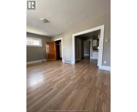 A room with wooden floors and a large open doorway.