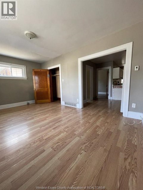 A room with wooden floors and a large open doorway.