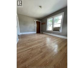 A room with wooden flooring and a window.
